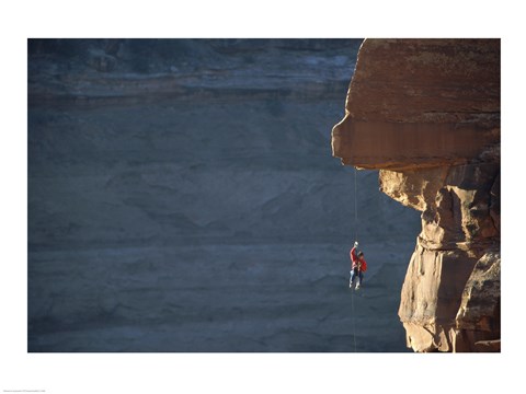 Framed Man hanging from a rope on the edge of a cliff Print