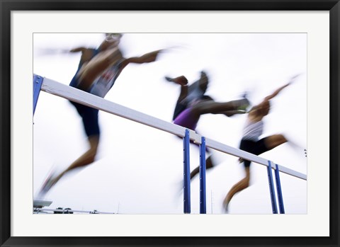 Framed Low angle view of three men jumping over a hurdle Print