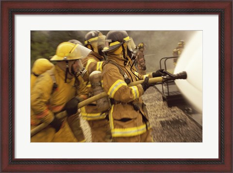 Framed Side profile of a group of firefighters holding water hoses Print