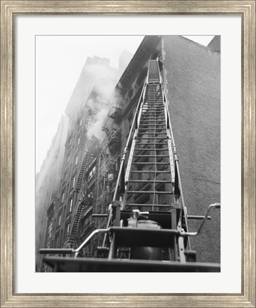 Framed Fire engine with ladder up burning building Print