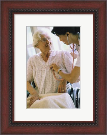 Framed Female nurse checking a female patient&#39;s heartbeat Print