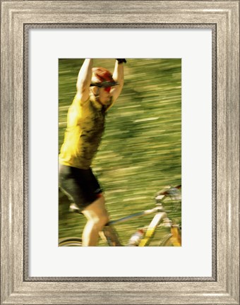 Framed Young man sitting on a bicycle with his arms raised Print