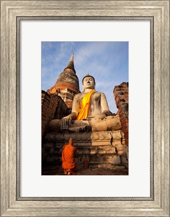 Framed Monk praying in front of a statue of Buddha Print