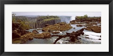 Framed Log on the rocks at the top of the Victoria Falls with Victoria Falls Bridge in the background, Zimbabwe Print