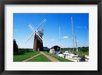 Framed Boat moored near a traditional windmill, River Ant, Norfolk Broads, Norfolk, England