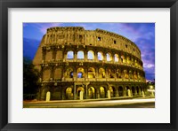 Low angle view of the old ruins of an amphitheater lit up at dusk, Colosseum, Rome, Italy Framed Print