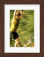 Framed Young man sitting on a bicycle with his arms raised