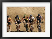 Group of people riding bicycles in a race Framed Print