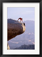 Framed Side profile of a young man pulling a young woman onto a rock