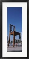 Framed Woman standing under a sculpture of large broken chair, Geneva, Switzerland