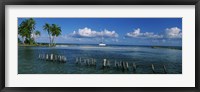 Framed Wooden posts in the sea with a boat in background, Laughing Bird Caye, Victoria Channel, Belize