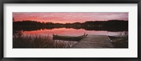 Framed Canoe tied to dock on a small lake at sunset, Sweden