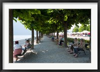 Framed People sitting on benches among trees at lakeshore, Lake Como, Cernobbio, Lombardy, Italy