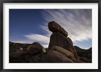 Framed Large boulders backdropped by stars and clouds, California