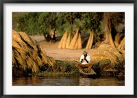 Framed Local Man Fishing and Piles of Straw for Hatch, Okavango Delta, Botswana