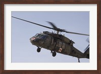 Framed UH-60 Blackhawk Medivac helicopter flies over Camp Warhorse